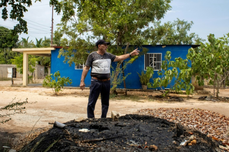 Eladio Ramón Devidez montre un monticule d’hydrocarbures dans la cour de son voisin près de Mene Grande, État de Zulia, Venezuela ( AFP / Margioni BERMÚDEZ )
