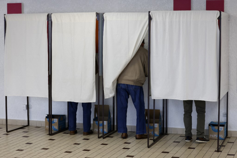 Un électeur dans un isoloir lors des législatives de 2024. ( AFP / LUDOVIC MARIN )