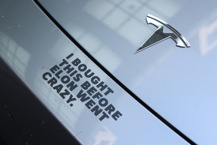 Un autocollant apposé sur le capot d'une voiture électrique Tesla affiche le message : «J'ai acheté ça avant qu'Elon ne devienne fou.» Le 29 avril 2025, à Berlin.  (crédit : SEAN GALLUP / GETTY IMAGES EUROPE / Getty Images via AFP)