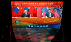 Le président russe Vladimir Poutine (g) et le président chinois Xi Jinping apparaissent sur un écran géant installé à l'extérieur d'un centre commercial à Pékin, le 4 février 2026, lors de la couverture médiatique un appel vidéo entre les deux dirigeants ( AFP / GREG BAKER )