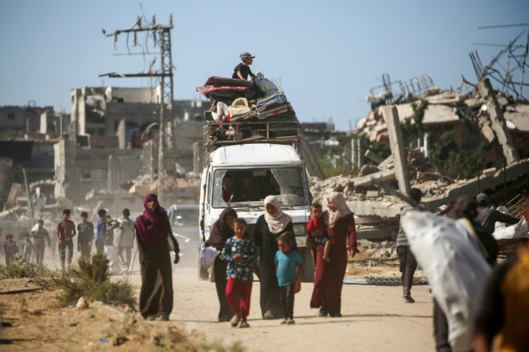 Des Palestiniens déplacés retournent chez eux, le 14 octobre 2025 dans la zone d'al-Zahra dans la bande de Gaza ( AFP / Eyad BABA )