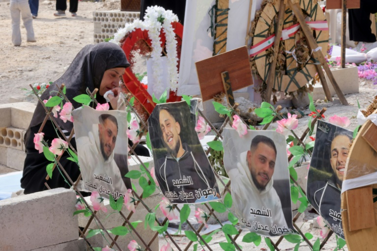 Une femme se recueille près d'une tombe tandis que des personnes déplacées par la guerre visitent des tombes temporaire où sont enterrés leurs proches tués lors du conflit au Sud-Liban, dans le village de Haret Saida, dans le sud du Liban, le 27 mai 2026 ( AFP / MAHMOUD ZAYYAT )