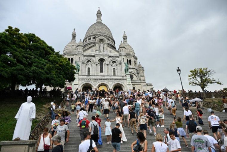 Des touristes montent vers la basilique du Sacré-Coeur à Montmartre, le 13 août 2025 à Paris ( AFP / Bertrand GUAY )