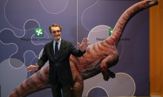 Attilio Fontana, président de la région italienne de Lombardie, pose pour une photo avec un dinosaure en carton lors d'une conférence de presse pour présenter la découverte de milliers d'empreintes de dinosaures dans le parc national du Stelvio, en Italie, près des zones qui accueilleront les Jeux olympiques d'hiver e Milan-Cortina 2026, à Milan, le 16 décembre 2025. On estime que ces empreintes appartiennent à des dinosaures prosauropodes du Trias supérieur, datant de 210 millions d'années. ( AFP / Piero CRUCIATTI )