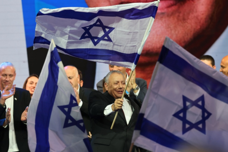 Gadi Eisenkot brandit un drapeau d'Israël, le 28 octobre 2026 à Tel-Aviv en Israël ( AFP / Jack GUEZ )