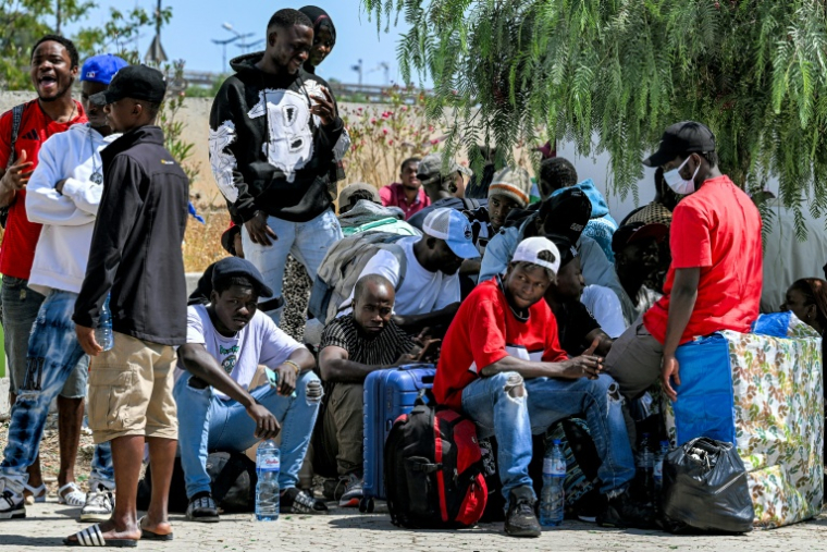 Des migrants sans papiers originaires de pays d'Afrique subsaharienne attendent les bus de l'aéroport avant leur rapatriement vers leurs pays d'origine, le 16 juin 2026 à Tunis ( AFP / FETHI BELAID )