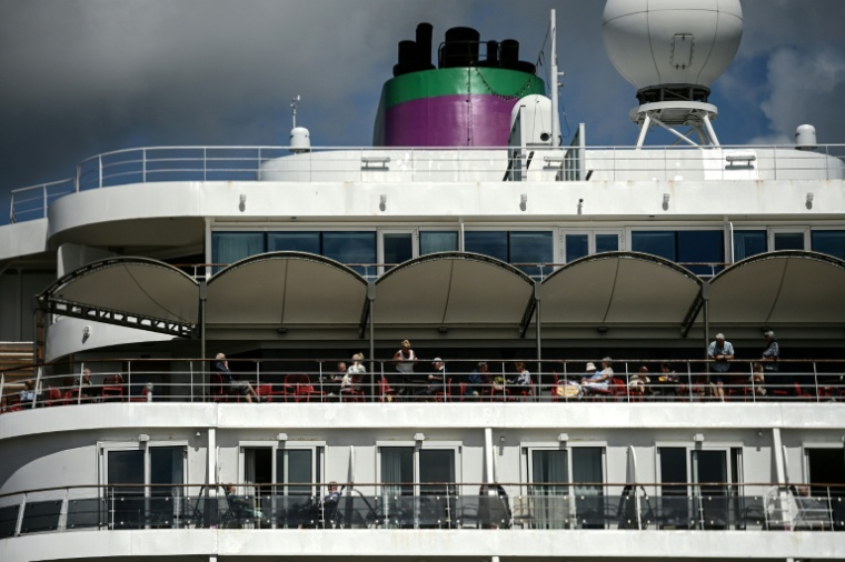 Des passagers du paquebot Ambition, confinés à bord dans le port de Bordeaux, le 13 mai 2026 en Gironde ( AFP / Christophe ARCHAMBAULT )