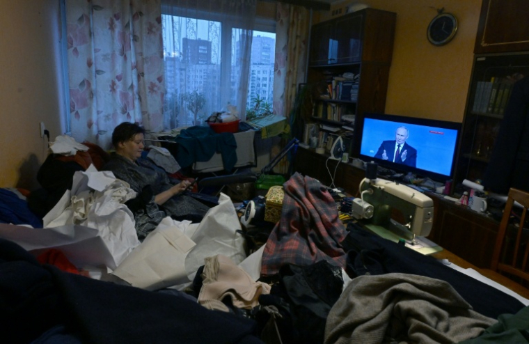 Une téléspectatrice dans son appartement de Saint-Pétersbourg lors de la retransmission en direct de la conférence de presse annuelle du président russe Vladimir Poutine, le 19 décembre 2025 ( AFP / Olga MALTSEVA )