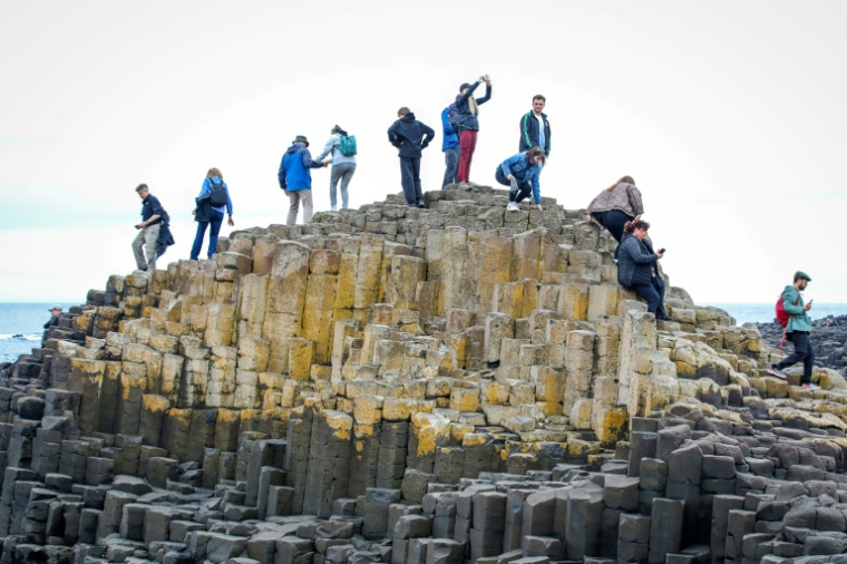 Des touristes visitent la Chaussée des Géants, site naturel près de Bushmills en Irlande du Nord, le 8 juillet 2025 ( AFP / PAUL FAITH )