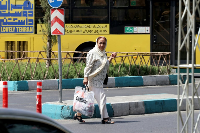 Une Iranienne traverse une rue sur la place Enghelab (Révolution), à Téhéran, le 24 juin 2025 ( AFP / ATTA KENARE )