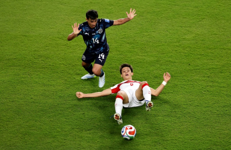 Arda Güler (au sol), le milieu offensif de la Turquie, face à Andres Cubas, le milieu défensif du Paraguay, lors d'un match du groupe D de la Coupe du monde 2026 opposant la Turquie au Paraguay, à Santa Clara, le 19 juin 2026 ( GETTY IMAGES NORTH AMERICA / Stu Forster )
