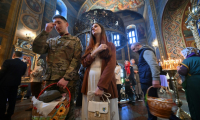 Un soldat ukrainien et son épouse au  monastère Saint-Michel-au-Dôme-d'Or, à l'occasion de la Pâque orthodoxe, le 20 avril 2025 à Kiev, en Ukraine ( AFP / Sergei SUPINSKY )