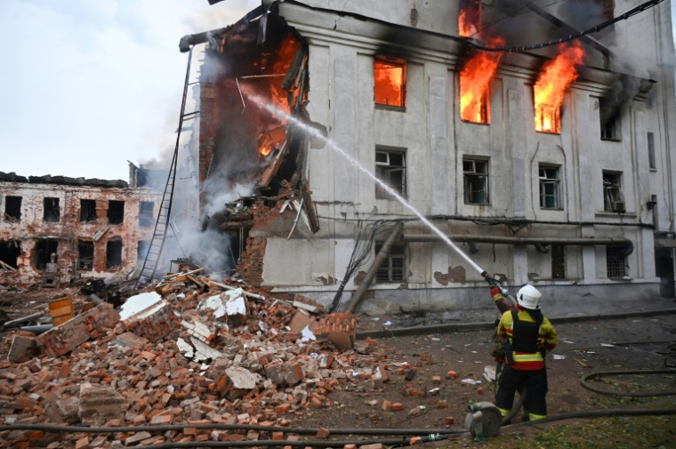 Un pompier lutte contre un incendie dans un bâtiment après une série d'attaques russes contre la ville de Kharkiv, dans l'est de l'Ukraine, le 7 juin 2025 ( AFP / SERGEY BOBOK )