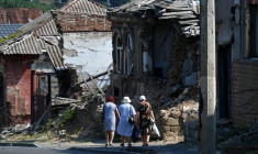 Dans un rue bordée de maisons détruites dans la cité portuaire de Marioupol occupée par les Russes, dans le sud de l'Ukraine, le 16 juillet 2025 ( AFP / Olga MALTSEVA )