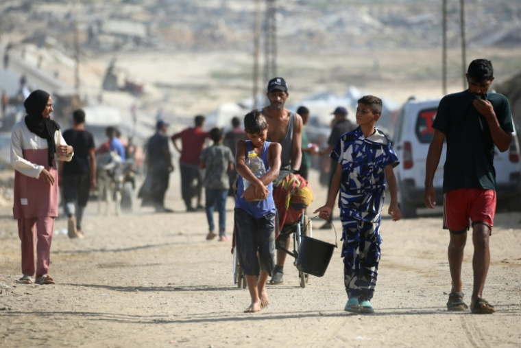 Des Palestiniens sur une route côtière au nord-ouest du camp de Nousseirat, empruntée par les déplacés se rendant vers le sud de la bande de Gaza après leur fuite du nord du territoire, le 4 octobre 2025 ( AFP / Eyad BABA )