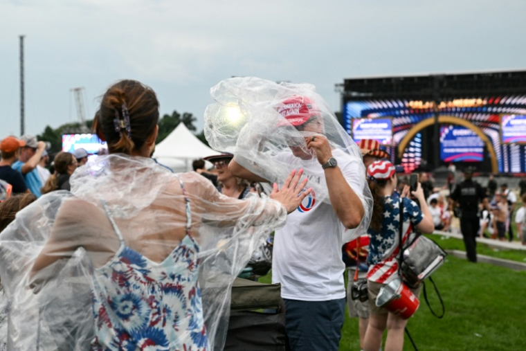 Des personnes enfilent des ponchos tandis qu’elles évacuent, en raison de la menace d'un orage, l'esplanade de Washington où se tiennent les festivités du 250e anniversaire des Etats-Unis, le 4 juillet 2026 ( AFP / Alex WROBLEWSKI )