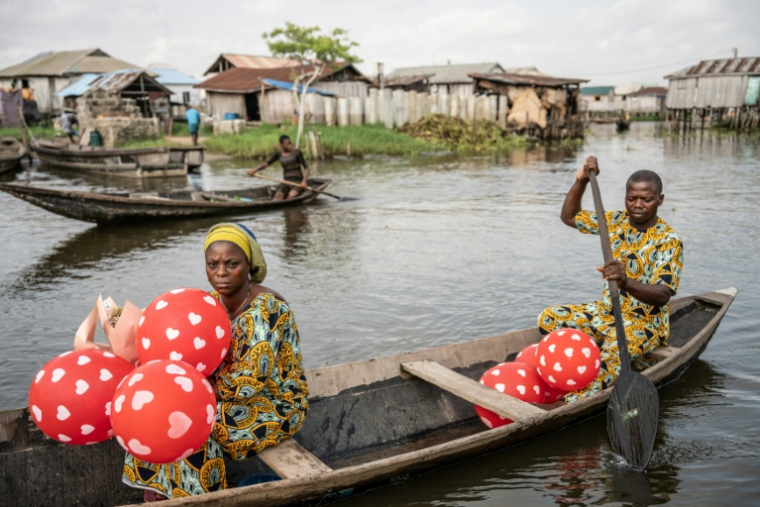 Un couple en pirogue quittent la Place des Amoureux après avoir fêté la Saint-Valentin dans la ville lacustre de Ganvié, le 10 février 2026 au Bénin ( AFP / Yanick Folly )