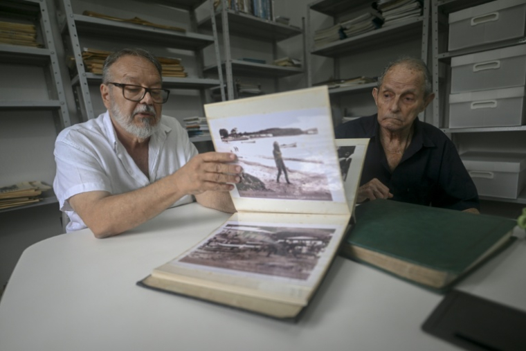 José Wilson, collectionneur, montre le 3 janvier 2026 des photos d'archives de Brigitte Bardot lors de son séjour à Buzios, au Brésil ( AFP / MAURO PIMENTEL )
