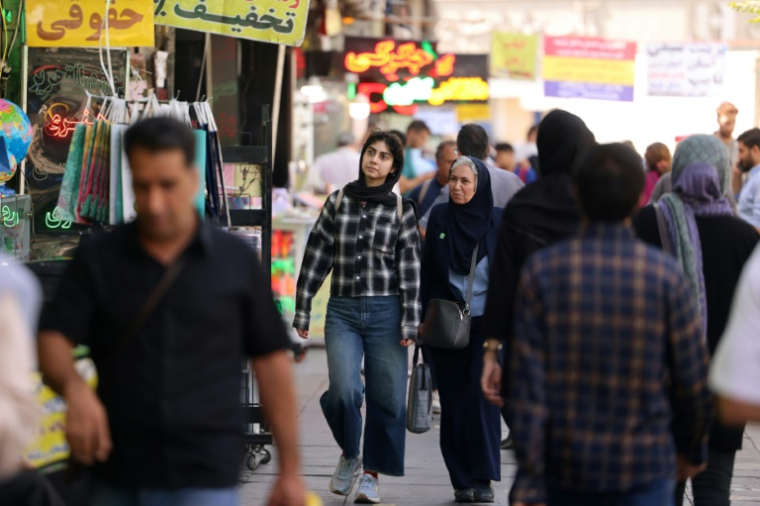 Des passants dans une rue animée de Téhéran, le 28 septembre 2025 en Iran ( AFP / ATTA KENARE )