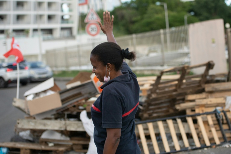 Une femme pompier près d'une barricade lors d'une grève générale à Fort-de-France le 27 novembre 2021 ( AFP / LOIC VENANCE )
