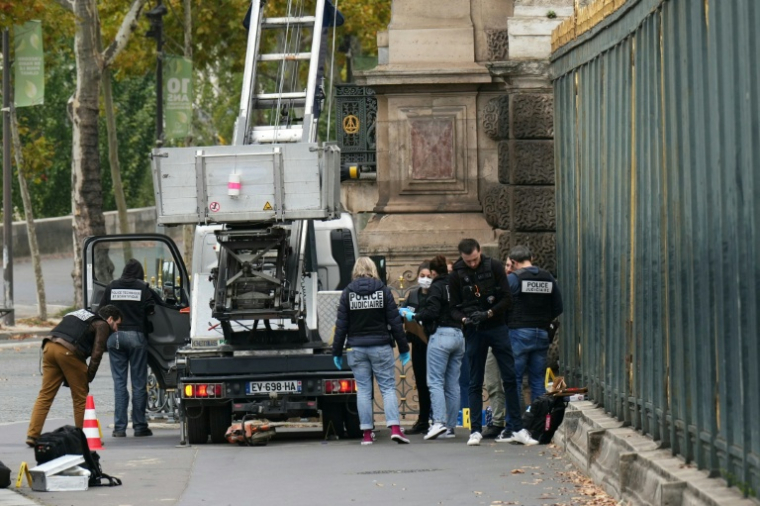 Des policiers inspectent le chariot élévateur utilisé par les voleurs pour entrer dans le musée du Louvre, à Paris le 19 octobre 2025 ( AFP / Dimitar DILKOFF )