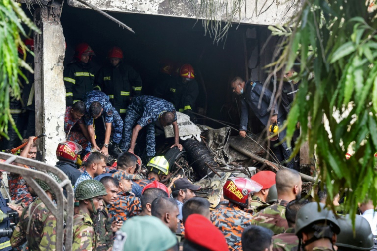 Des secouristes bangladais sur les lieux du crash d'un avion militaire, tombé sur une école de Dacca, le 21 juillet 2025 ( AFP / Abdul Goni )