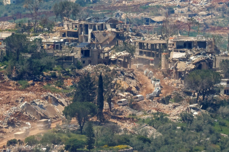 Photo prise depuis le nord d'Israël montrant un convoi des Nations unies (ONU) circulant à proximité de maisons détruites dans le sud du Liban, près de la frontière avec Israël, le 29 avril 2026 ( AFP / Jalaa MAREY )