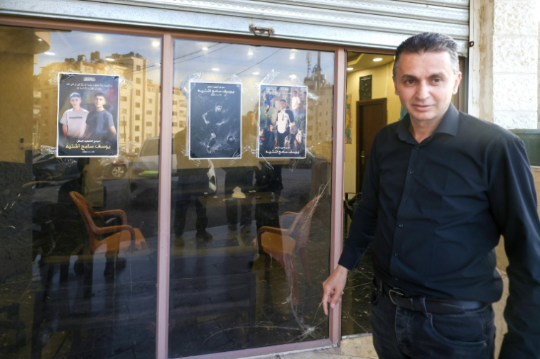 Sameh Shtayyeh, père de l'adolescent Youssef Shtayyeh, tué le 23 avril 2026 par des soldats israéliens, passe devant une photo de son fils jouant au football, à Tell, près de Naplouse, en Cisjordanie occupée, le 12 mai 2026 ( AFP / JAAFAR ASHTIYEH )