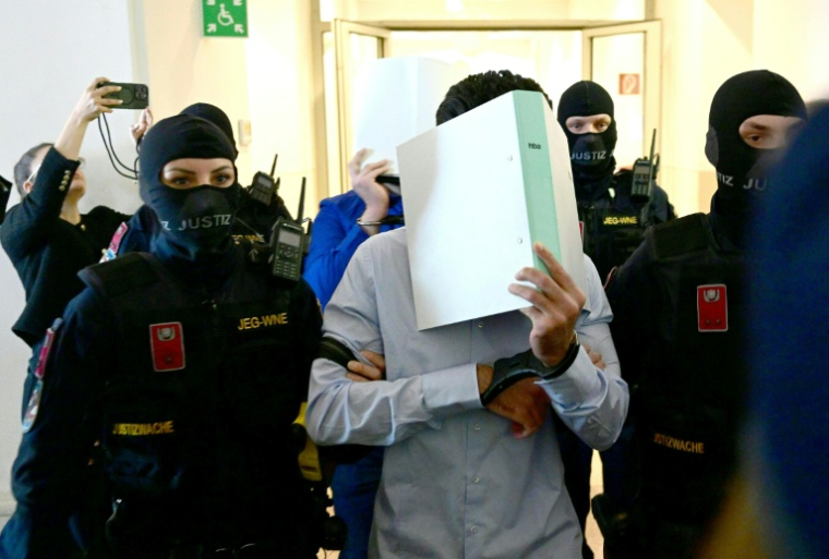 Deux prévenus sont escortés vers la salle d'audience pour comparaître lors du procès d'un projet d'attentat islamiste contre un concert de Taylor Swift, au tribunal de Wiener Neustadt, en Autriche, le 28 avril 2026 ( APA / ROLAND SCHLAGER )