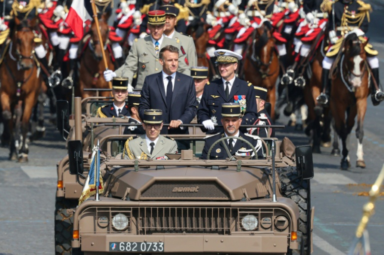 Le président Emmanuel Macron au côté du chef d'état-major des Armées Fabien Mandon descend les Champs-Elysées mardi pour son dernier défilé du 14-Juillet ( AFP / Ludovic MARIN )