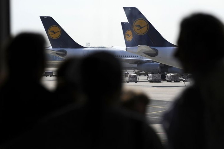 La silhouette de passagers près d'avions de Lufthansa à l'aéroport de Francfort