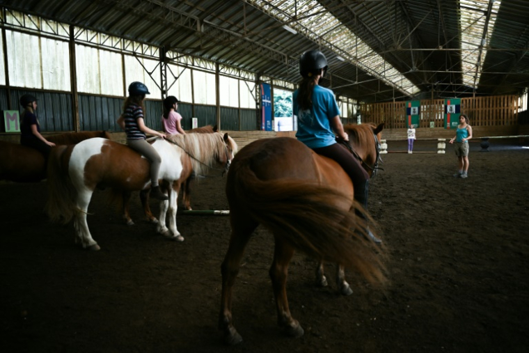 Des enfants montent des poneys dans la ferme équestre de Bois Guilbert, en Seine-Maritime, le premier poney-club à avoir vu le jour dans l'Hexagone, le 1er juillet 2025 ( AFP / Lou BENOIST )