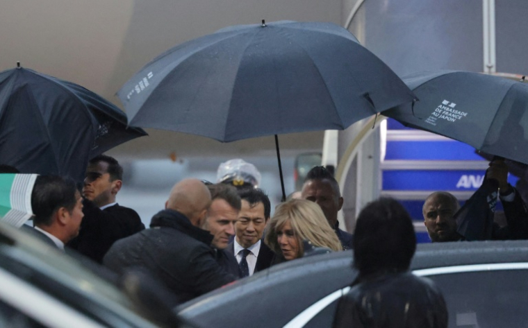 Le président français Emmanuel Macron (c,g) et son épouse Brigitte Macron à leur arrivée à l'aéroport de Tokyo, le 31 mars 2026 ( AFP / Ludovic MARIN )