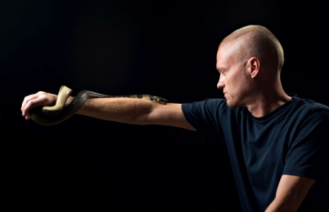 Photo non datée obtenue auprès de Centivax, le 30 mai 2025, de l'Américain Tim Friede, qui s'est exposé au venin de serpent des centaines de fois dans le but de renforcer son immunité, avec un cobra d'eau sur son bras ( CENTIVAX / - )