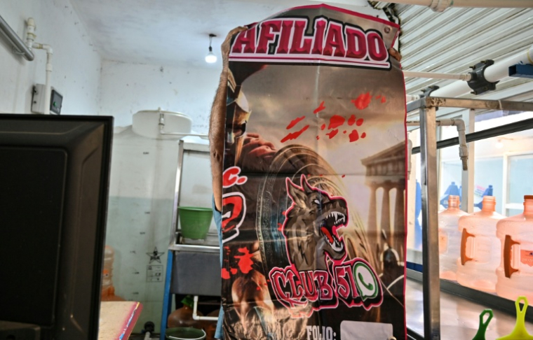 Une affiche sur le stand d'un marché municipal indique une affiliation payante à un groupe privé contre l'extorsion à Ecatepec, dans l'Etat de Mexico, le 2 octobre 2025 ( AFP / Yuri CORTEZ )