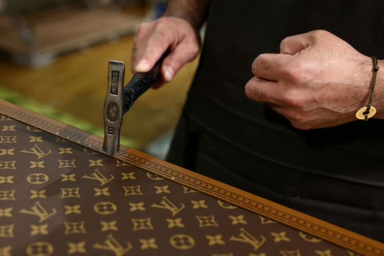 Un employé travaille sur la fabrication d'une malle Louis Vuitton
