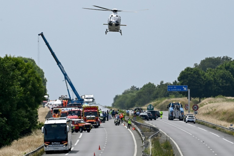 Une grue et des véhicules de secours sur l'autoroute A81, à Degré, dans la Sarthe, après un accident de car mortel, le 13 juin 2025 ( AFP / JEAN-FRANCOIS MONIER )