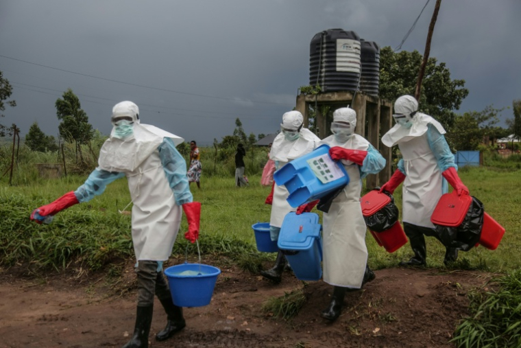 Des soignants portant des équipements de protection individuelle transportent du désinfectant à l’hôpital de Rwampara, en République démocratique du Congo, frappée par une épidémie d'Ebola, le 21 mai 2026. ( AFP / Seros MUYISA )