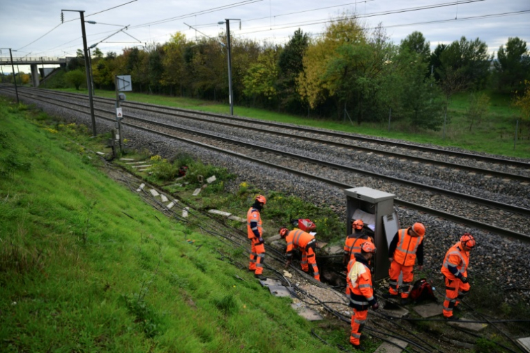 Des agents de la SNCF interviennent pour remplacer des câbles endommagés après un acte de vandalisme, au sud de Valence, le 27 octobre 2025 dans la Drôme ( AFP / Olivier CHASSIGNOLE )