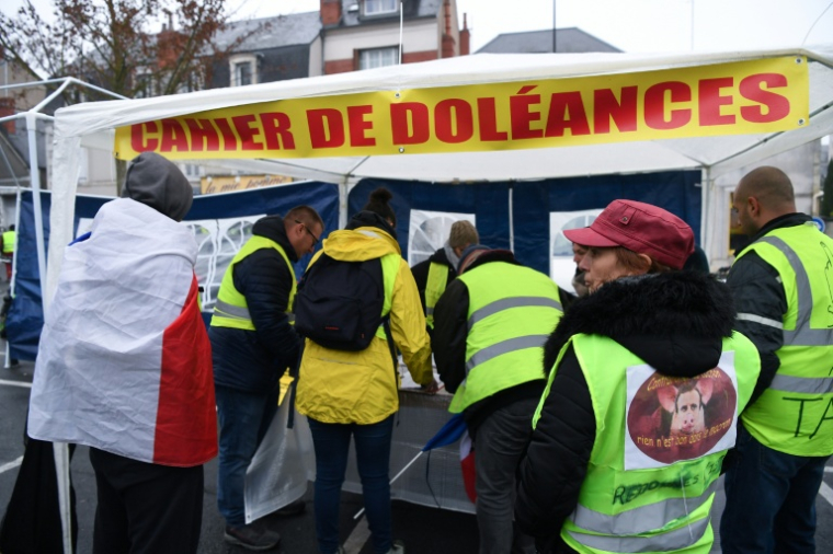 Des personnes signent le cahier de doléances lors d'une manifestation antigouvernementale organisée par le mouvement des "Gilets jaunes" à Bourges, le 12 janvier 2019 ( AFP / Alain JOCARD )
