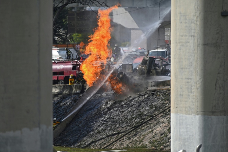 Des pompiers mexicains éteignent les flammes provenant d'un camion-citerne qui a explosé, dans l'est de Mexico, le 10 septembre 2025 ( AFP / Valentina Alpide )