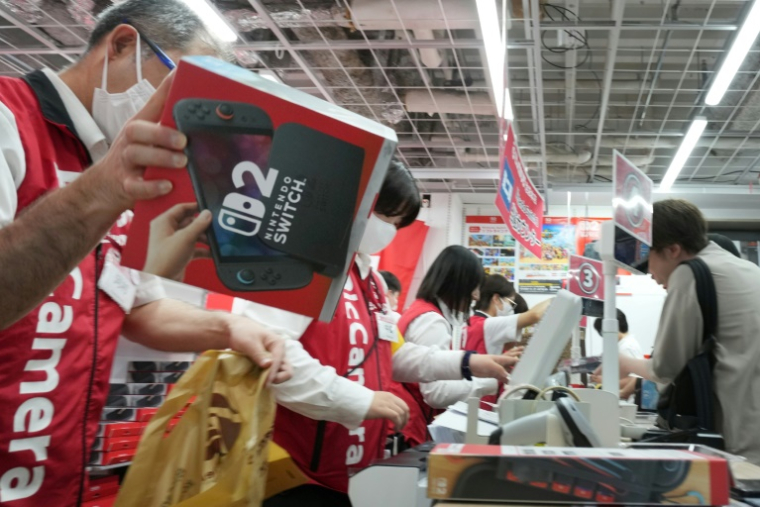 Des clients achètent la Nintendo Switch 2 dans un magasin d'électronique à Tokyo, le 5 juin 2025 ( AFP / Kazuhiro NOGI )