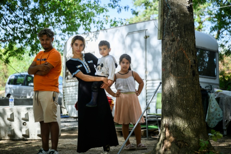 Une famille de la communauté rom pose dans un nouveau bidonville à Nantes, le 31 août 2026 ( AFP / Loic VENANCE )