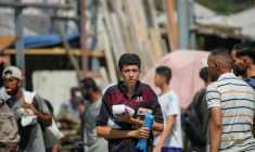 Des déplacés palestiniens portent des produits alimentaires obtenus à un point de distribution du centre de la bande de Gaza, le 26 juillet 2025 ( AFP / Eyad BABA )