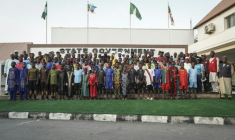 Des écoliers posent pour une photo avec les autorités gouvernementales au bureau du gouverneur local à Minna, le 8 décembre 2025. Une centaine d'écoliers qui avaient été enlevés le mois dernier par des hommes armés dans une école catholique sont arrivés au siège du gouvernement à Minna, la capitale de l'État du Niger, dans le centre-nord du Nigeria, comme l'ont observé lundi des journalistes de l'AFP. Cependant, le sort des 165 autres personnes enlevées avec eux reste inconnu. Les élèves, âgés pour la plupart de 10 à 17 ans, sont arrivés dans cinq bus blancs escortés par une dizaine de véhicules militaires et blindés et ont été reçus par le gouverneur de l'État du Niger, Mohammed Umaru Bago. ( AFP / Light Oriye Tamunotonye )