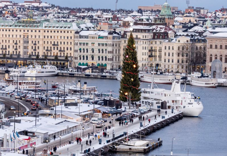 Des gens se promènent le long du quai Skeppsbron à Stockholm