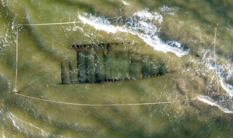 Vue aérienne d'une épave vieille de plusieurs siècles, découverte après le passage du typhon Kalmaegi, sur une plage au large de Hoi An, dans le centre du Vietnam, le 9 novembre 2025 ( AFP / Tam Xuan )