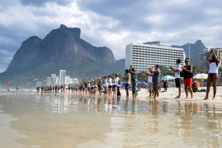Manifestation pour célébrer la Journée mondiale des Océans, le 8 juin 2025 sur la plage de Sao Conrado à Rio de Janeiro (Brésil) ( AFP / Pablo PORCIUNCULA )