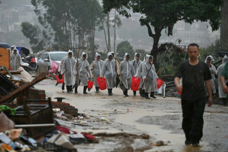 Des sécouristes participent aux opérations de nettoyage dans le village de Liulan, inondé après l'effondrement, du réservoir de Liulan, à Hengzhou, dans la région chinoise du Guangxi, le 8 juillet 2026 ( AFP / GREG BAKER )