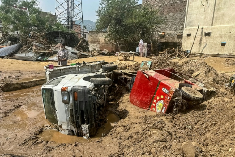 Véhicules endommagés et débris jonchent les rues de Mingora après l'effondrement de la route suite aux crues subites dans la province montagneuse de Khyber Pakhtunkhwa au Pakistan le 16 août 2025 ( AFP / Mehboob UL HAQ )